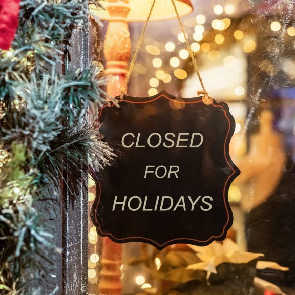 Sign reading “Closed for the Holidays” surrounded by festive Christmas decorations, representing business festive shutdown period