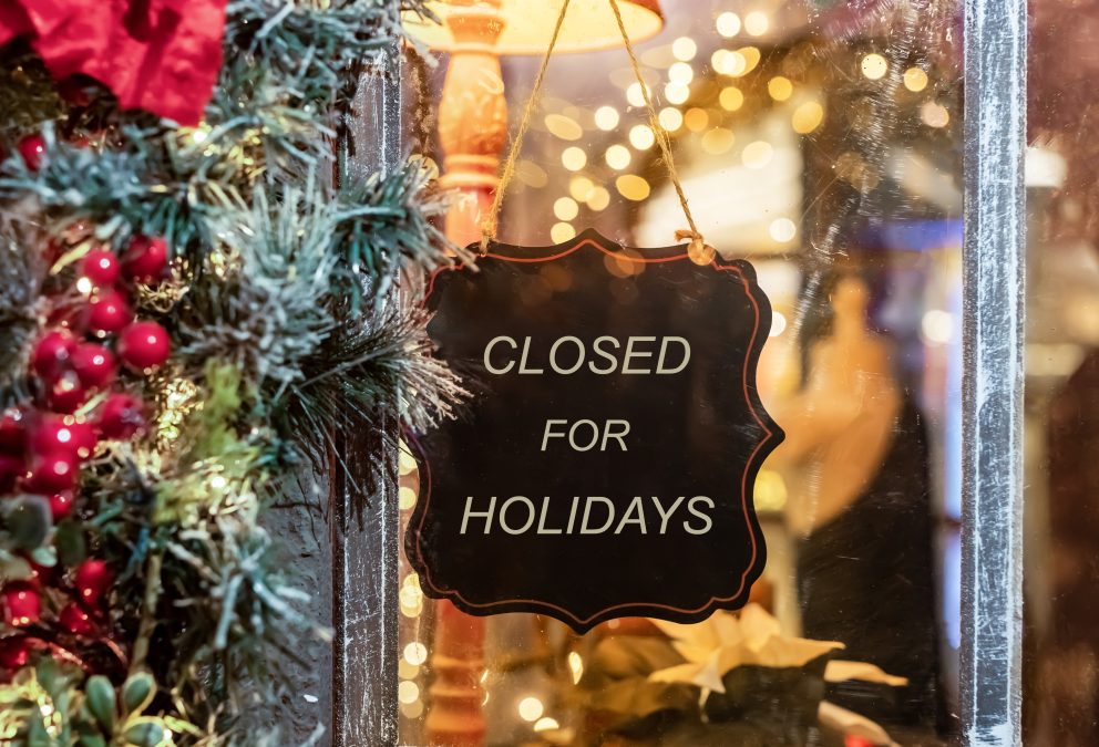 Sign reading “Closed for the Holidays” surrounded by festive Christmas decorations, representing business festive shutdown period